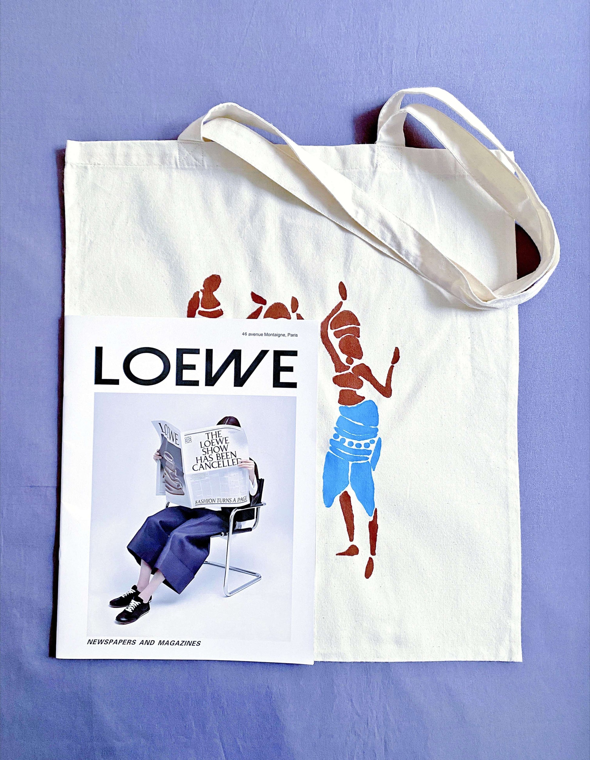 Oversized tote draped over a shoulder, turning a simple jeans-and-tee outfit into a statement of effortless artistic style.