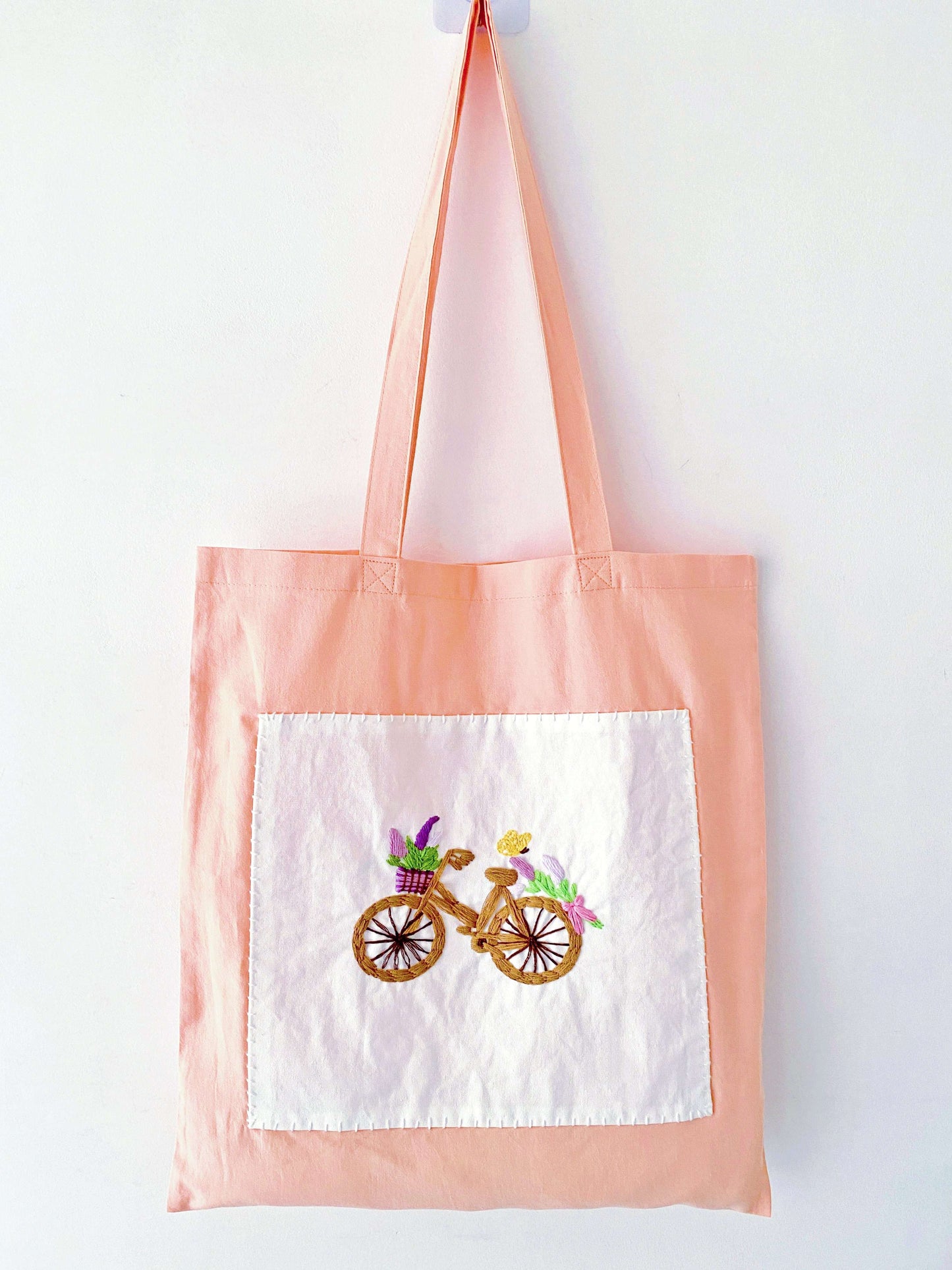 Styling a pop of orange with a vintage denim look, showing how this sustainable hand embroidered accessory adds artistic flair to casual wear.