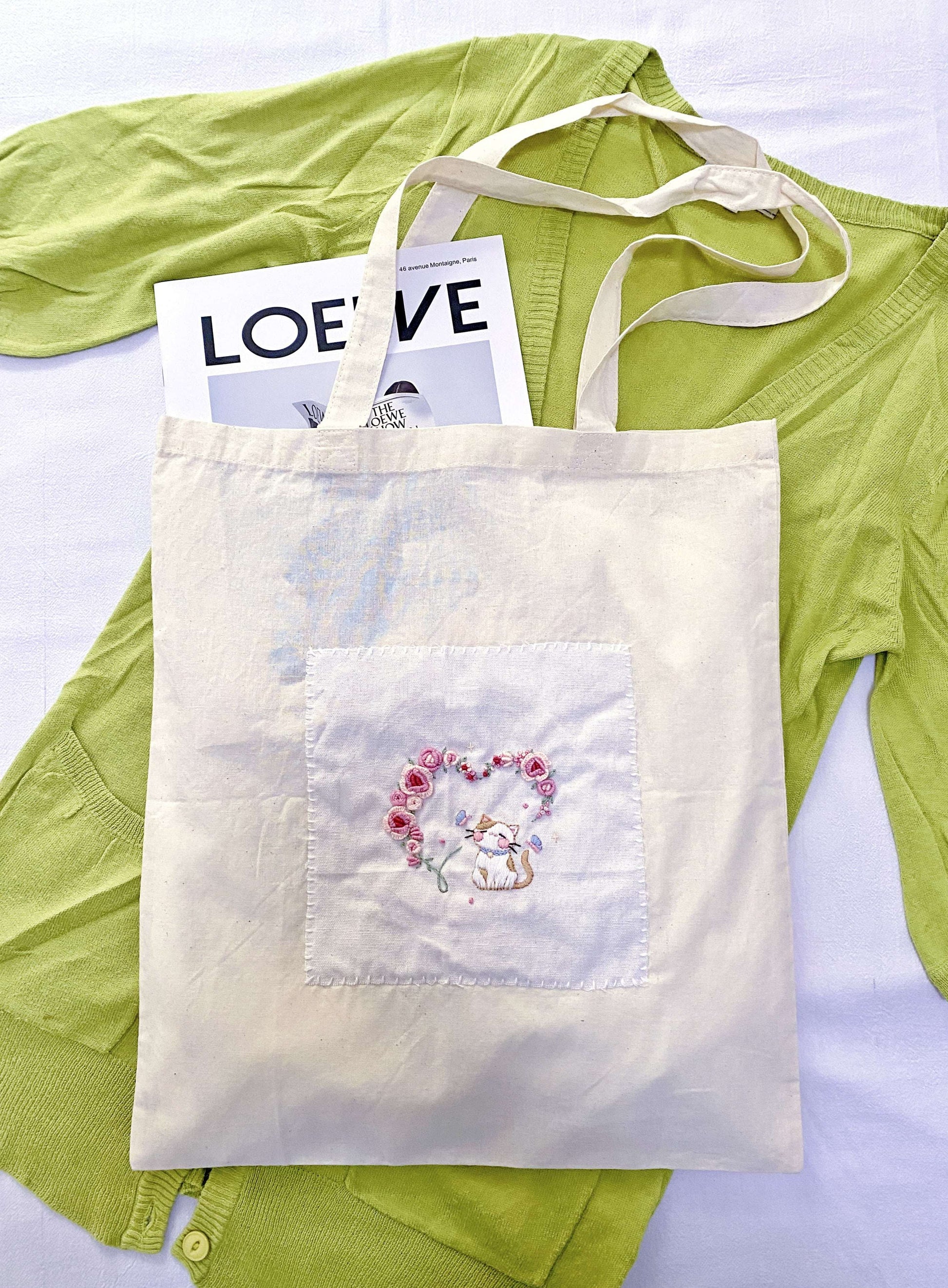 Tactile view of organic cotton weave with delicate handcrafted needlework.