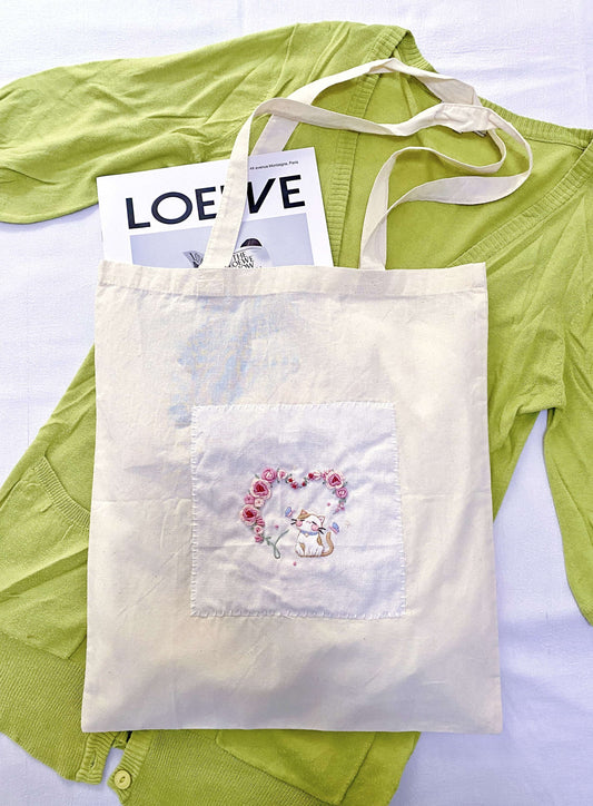 Tactile view of organic cotton weave with delicate handcrafted needlework.