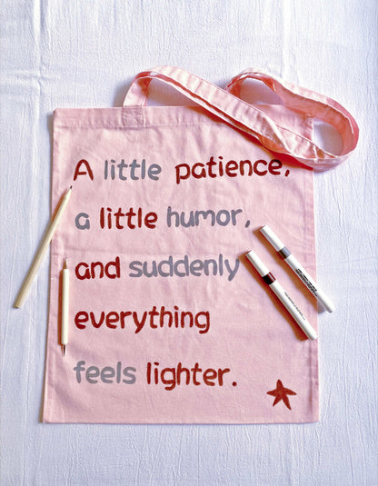 Eco-friendly pink tote bag with a hand-lettered quote, designed for those who appreciate conscious living and minimalistic accessories.