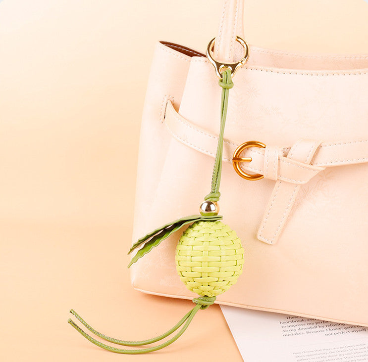 Lime green woven charm styled on a tote bag