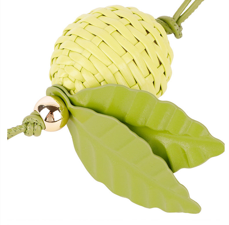 Green leaf charm paired with a casual canvas tote