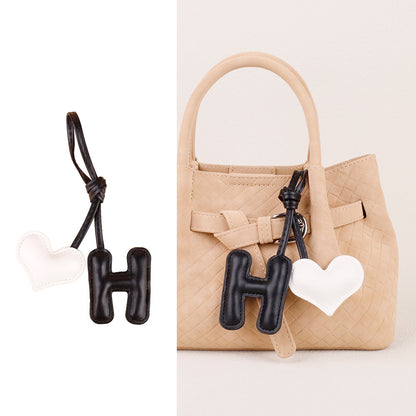 Cute letter pendant hanging from a purse strap