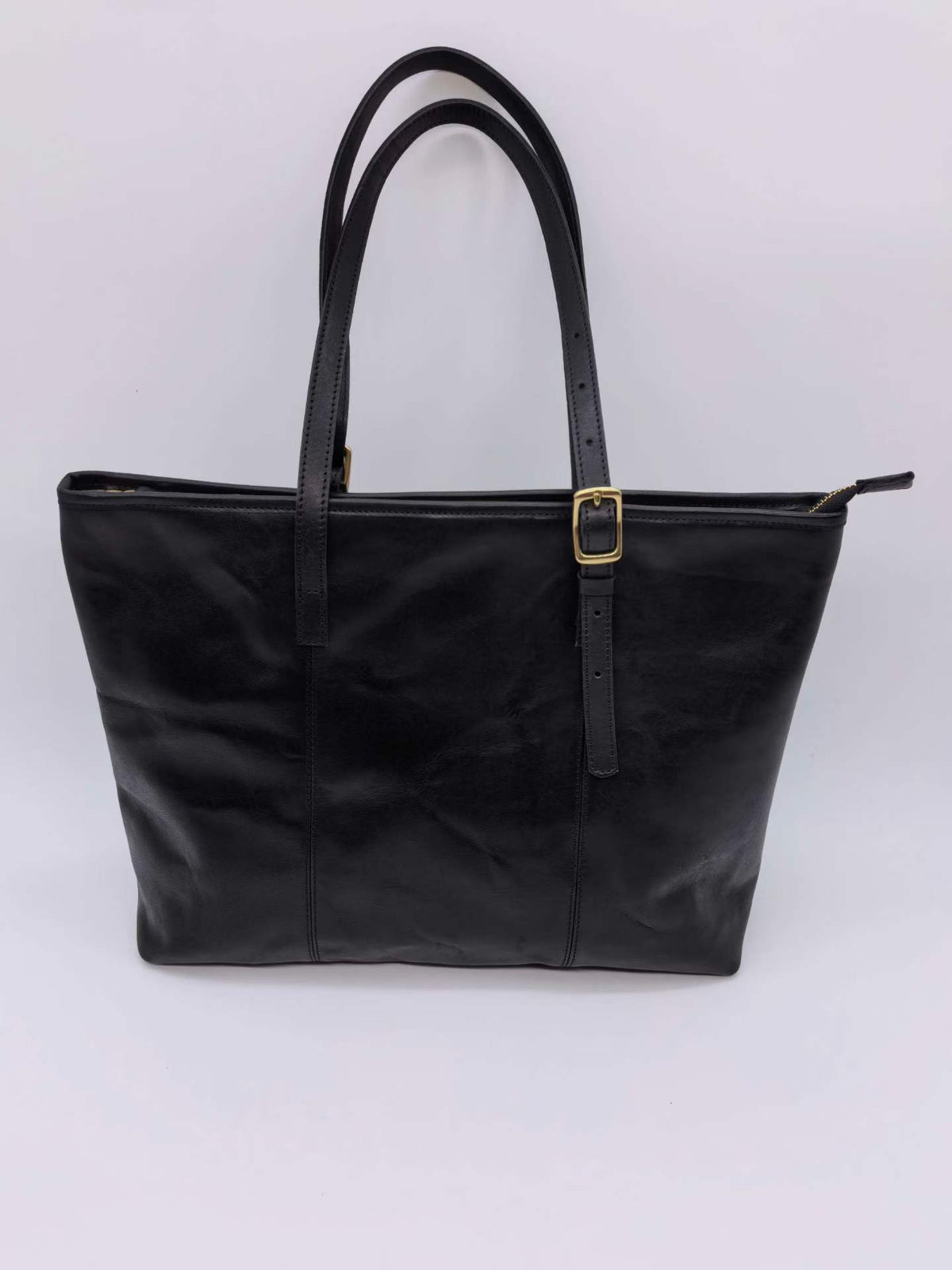 Spacious leather handbag with a top zipper for carrying essentials while commuting.