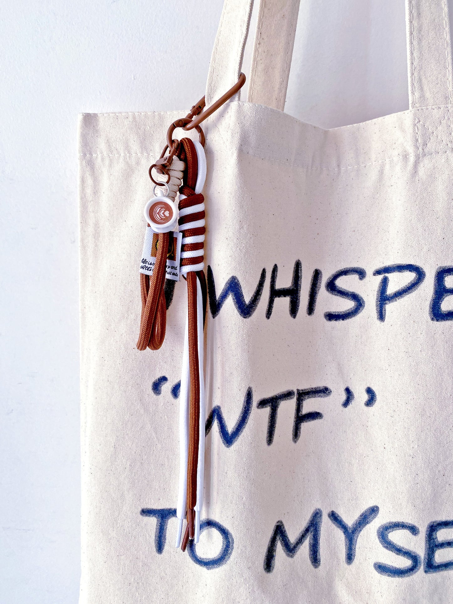 a foldable tote bag gently placed beside a coffee and a notebook