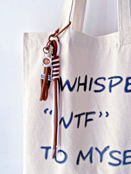 a foldable tote bag gently placed beside a coffee and a notebook