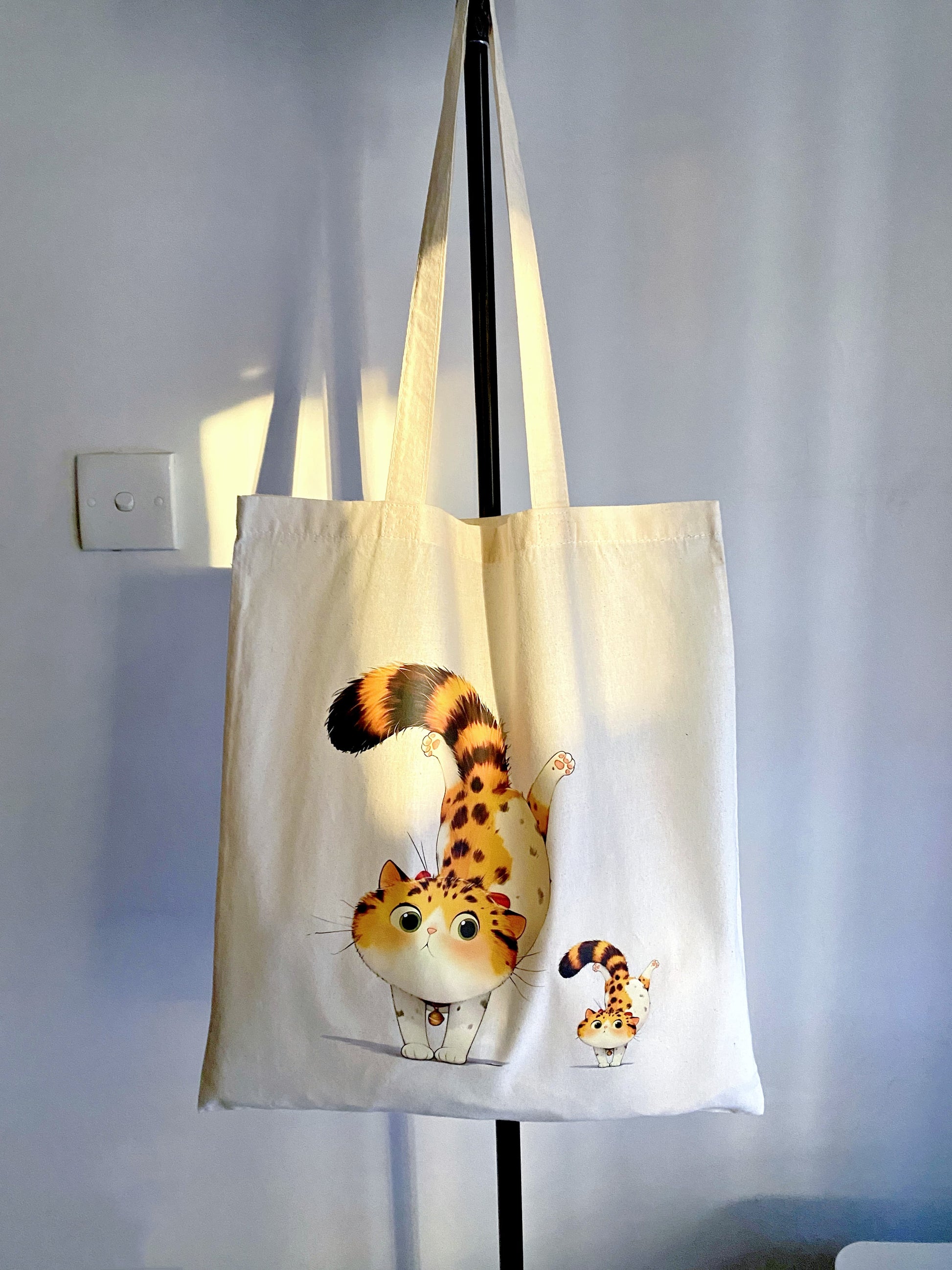 The playful orange cat design on this spacious, eco-friendly tote bag makes it a great gift for friends or family.