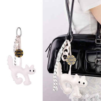Cat charm with woven cord placed inside a surprise gift box