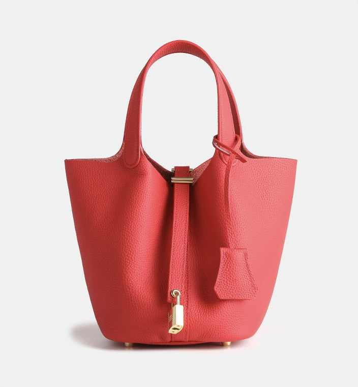 compact leather bucket bag worn crossbody during a city walk