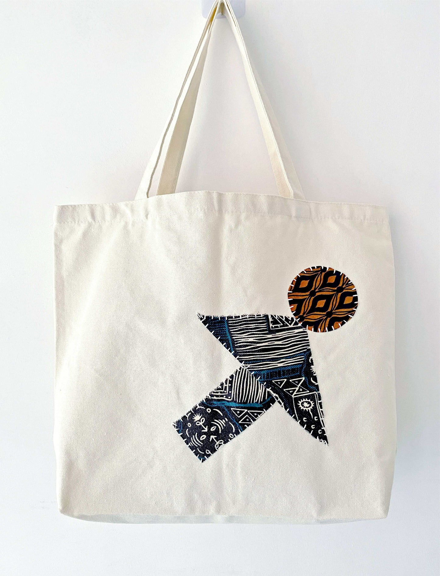 Large natural canvas tote filled with fresh baguettes and flowers, showing the durable weight capacity for weekly zero-waste market runs without losing shape.