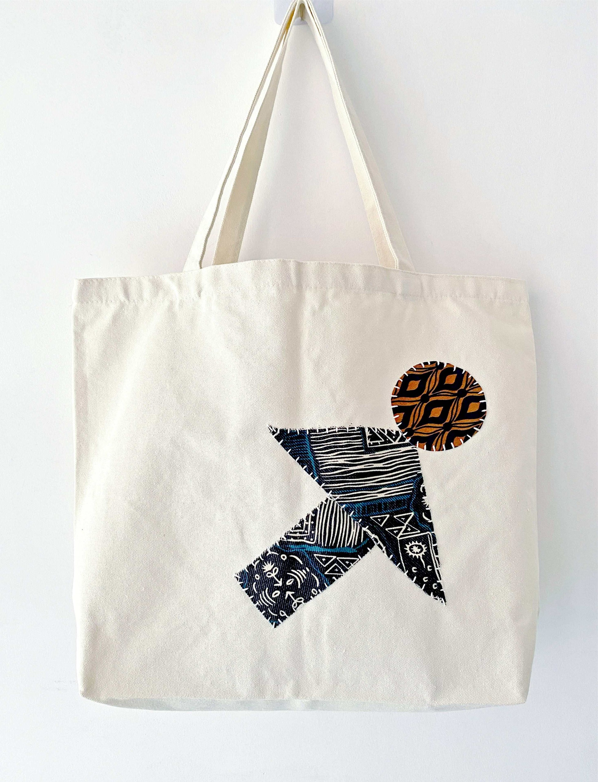 Large natural canvas tote filled with fresh baguettes and flowers, showing the durable weight capacity for weekly zero-waste market runs without losing shape.