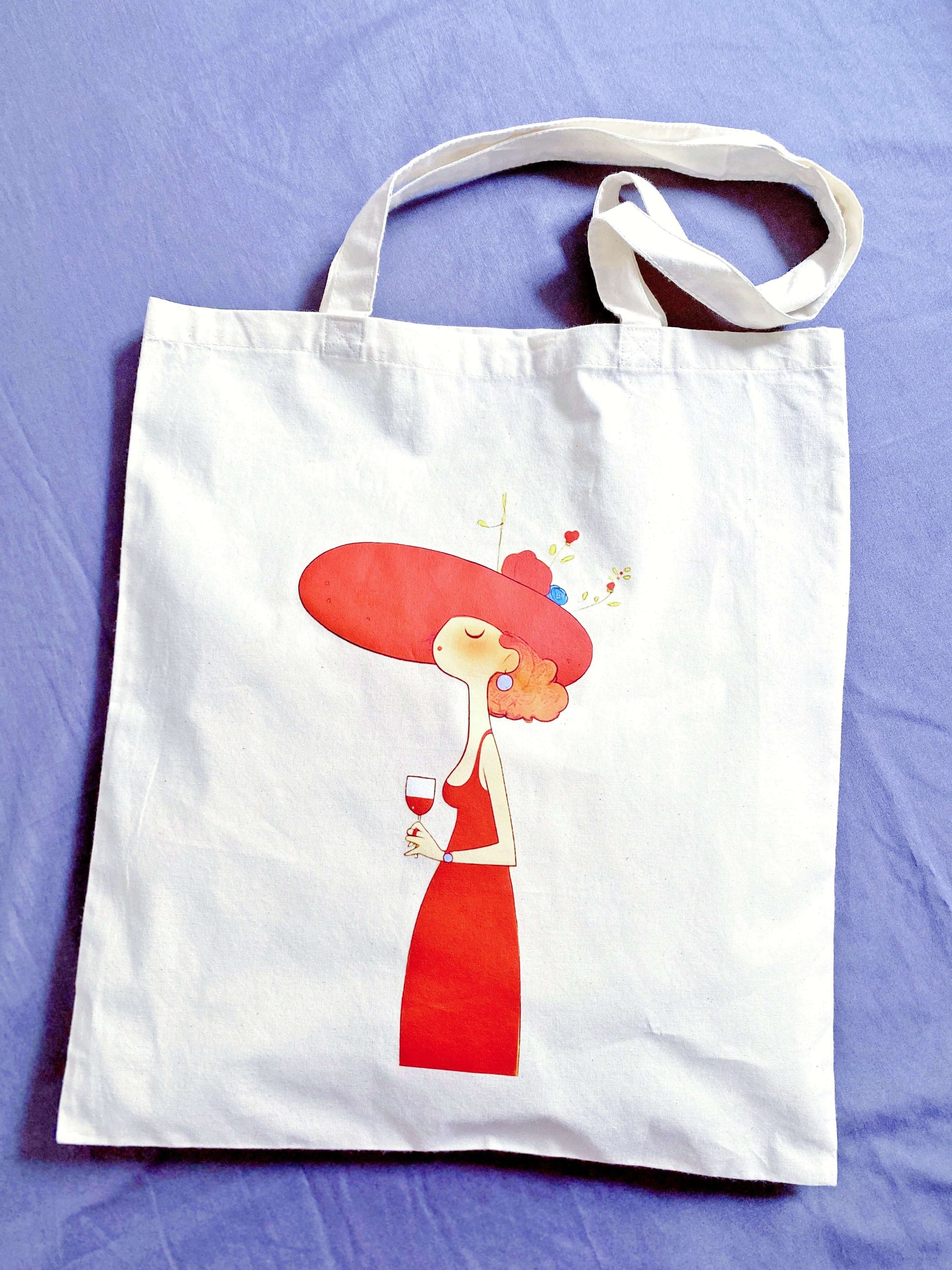 Casual artistic tote draped over a wooden chair in a sunny cafe.