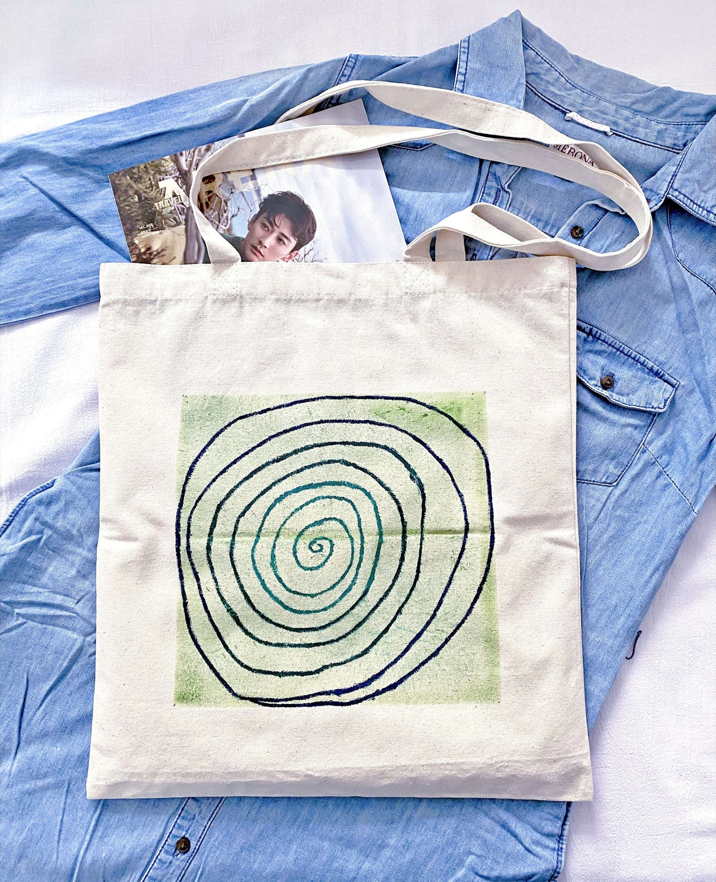 A tall woman wearing a neutral linen outfit paired with a slouchy hand-painted bag.
