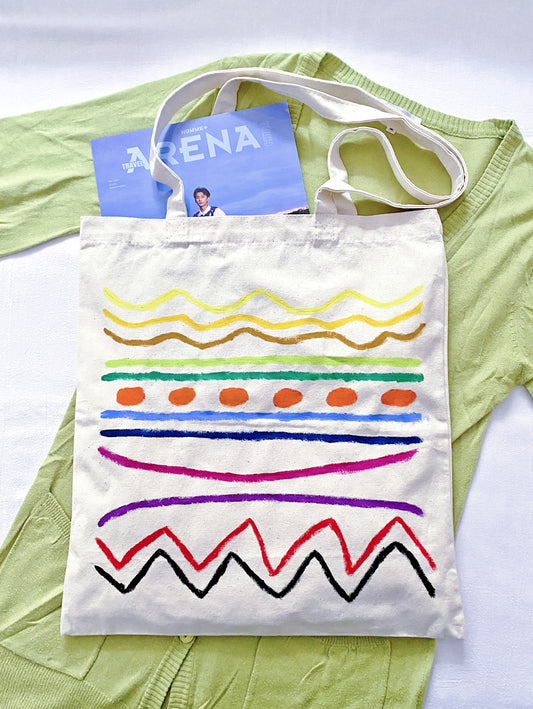 Person wearing a slouchy cream tote bag with an oversized linen shirt.