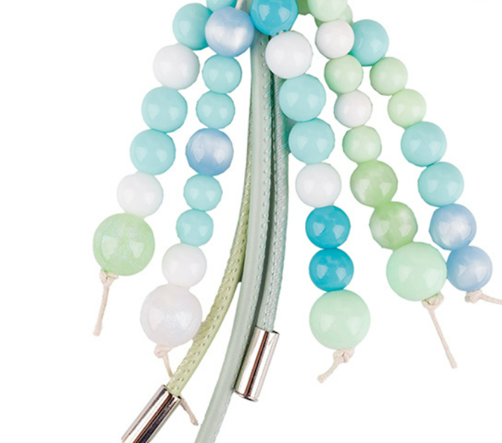 Green stone keychain accessory with long soft tassels