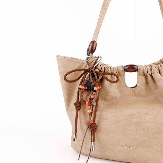 Handmade tassel charm hanging from a handbag