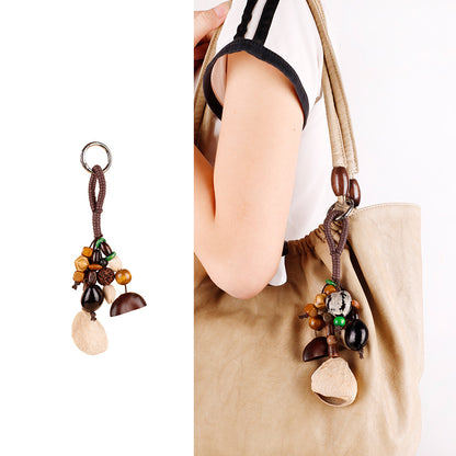 Natural wood and shell beads arranged as a hanging keychain