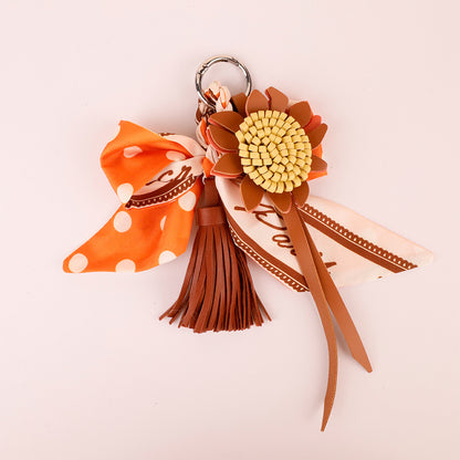 Orange tassel bow accessory for adding detail to a tote