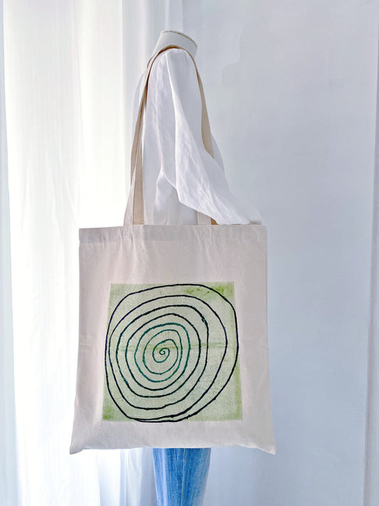 The lived-in look of a spacious cotton bag filled with a yoga mat and water bottle.