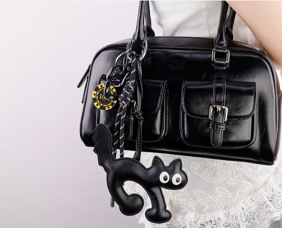Hand-assembled cat purse charm with hand-woven lanyard shown up close