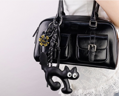 Hand-assembled cat purse charm with hand-woven lanyard shown up close