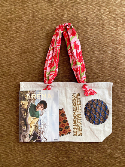Minimal tote bag with stitched patchwork held casually during weekend errands