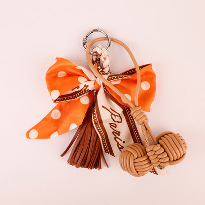 Orange bow keychain charm with scarf and tassel details