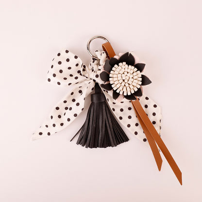 Classic polka dot scarf ornament decorating a structured top handle bag