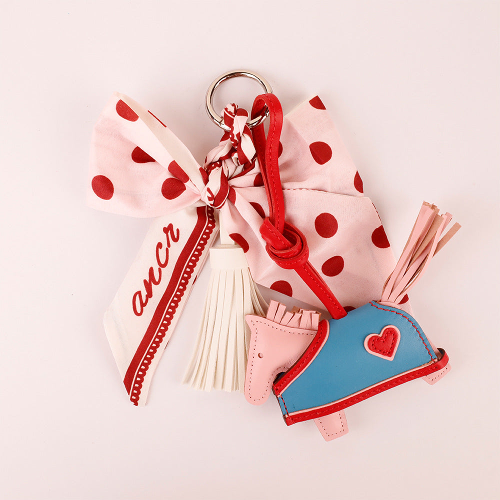Pink bow charm attached to a handbag handle
