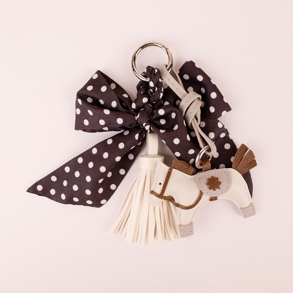 Handcrafted ribbon key holder placed flat on an unbleached cotton background
