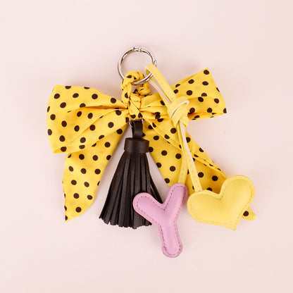 Yellow handmade charm with bow and tassel accents