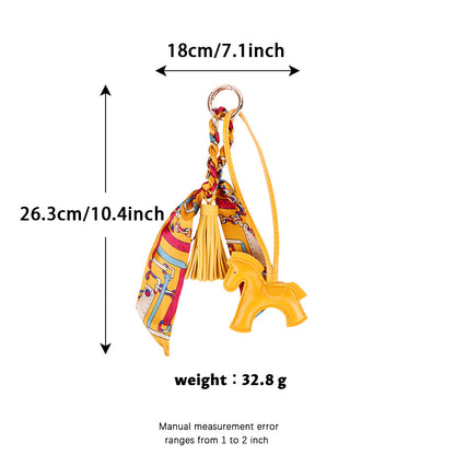 Horse scarf ornament displayed beside a structured handbag