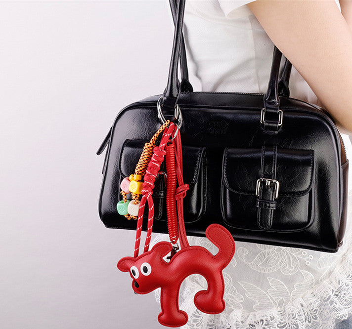 Small puppy doll charm with woven cord