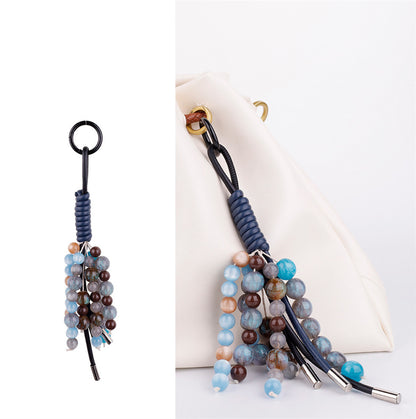 Purple natural gemstone charm attached to a casual canvas crossbody