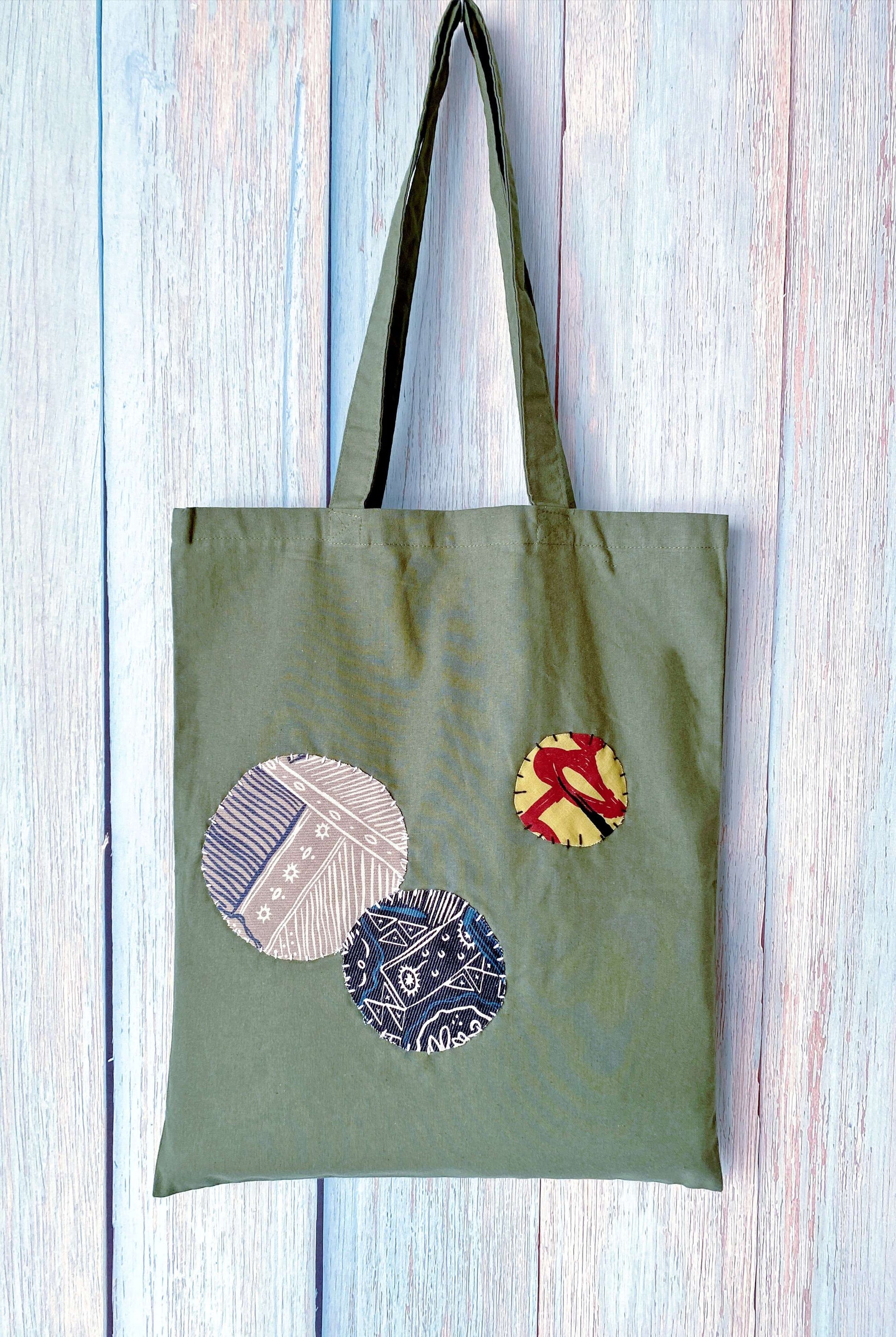 Softer than stiff canvas, this olive cotton bag with patchwork is the comfort item she grabs first.