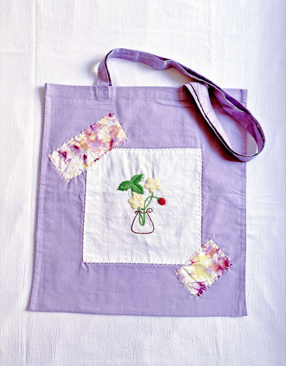 Foldable purple cotton bag being packed into suitcase, a compact extra carrier for eco-conscious travelers.