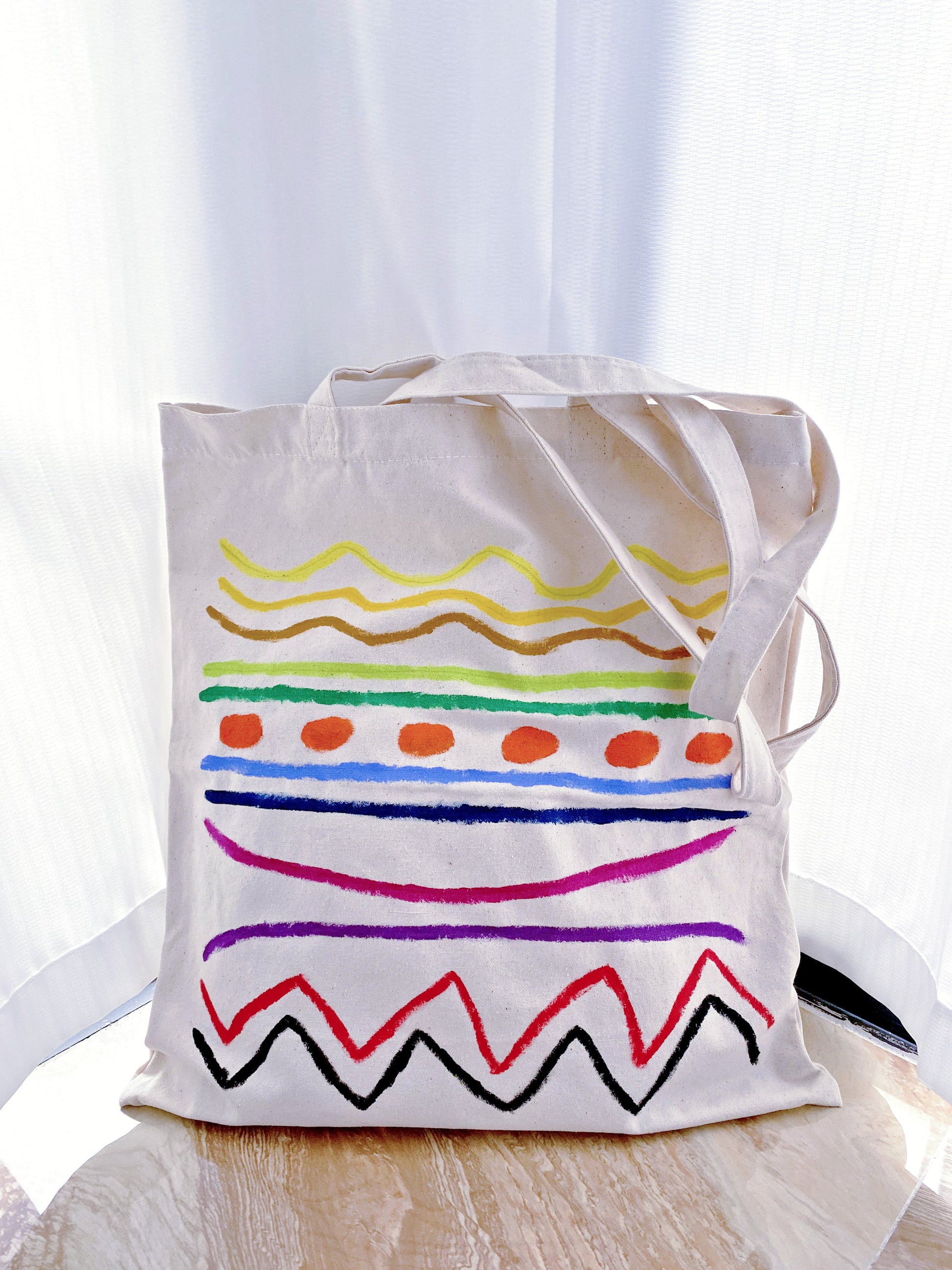 Quiet luxury accessory: a simple canvas tote with subtle artistic flair.