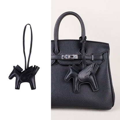 Compact horse purse pendant hanging alongside a luxury key set for daily use