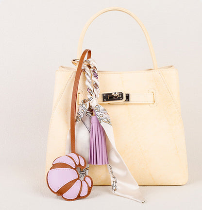 Small scarf accent attached to a structured shoulder bag