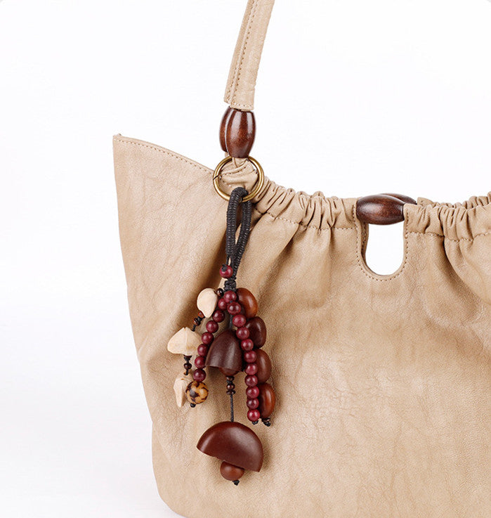 Natural fruit shell charm clipped to a handbag