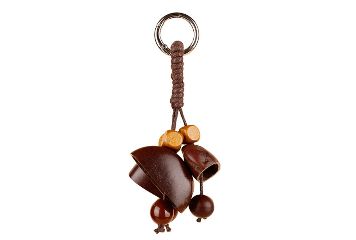 Fruit shell and wooden bead keychain hanging from a bag