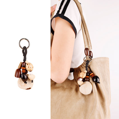 Small shell bead pendant attached to a woven bag handle