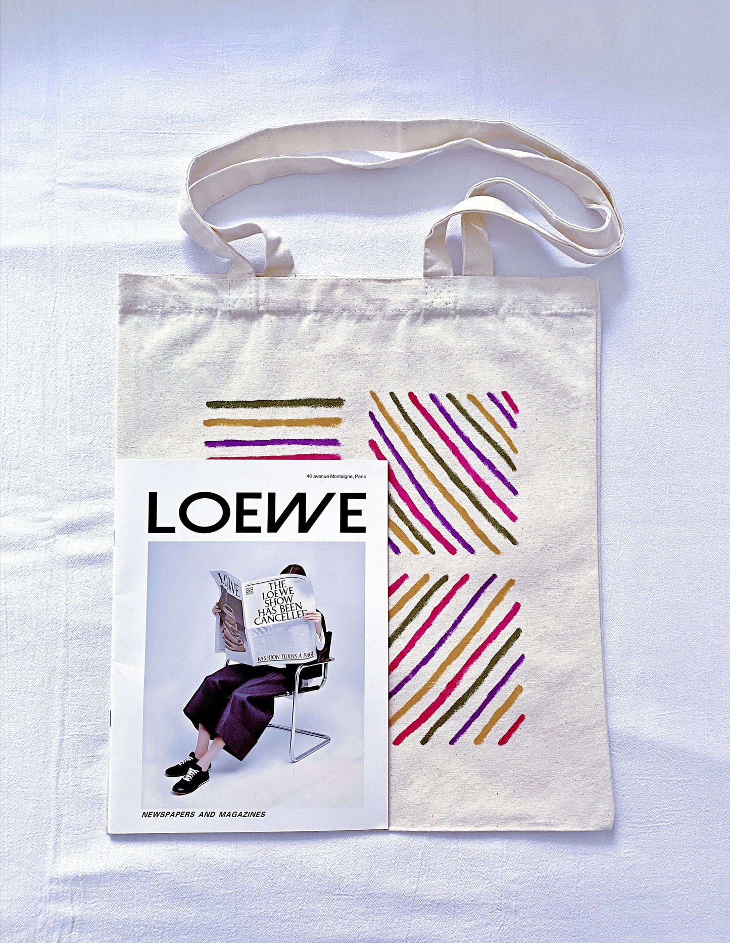 A person carrying a large canvas carryall for a weekend art gallery visit.