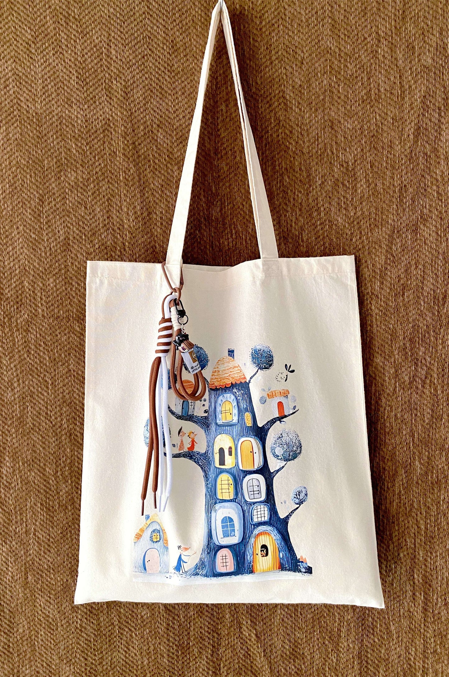 Close-up of a slouchy cream cotton tote showing hand-stamped leaf patterns.