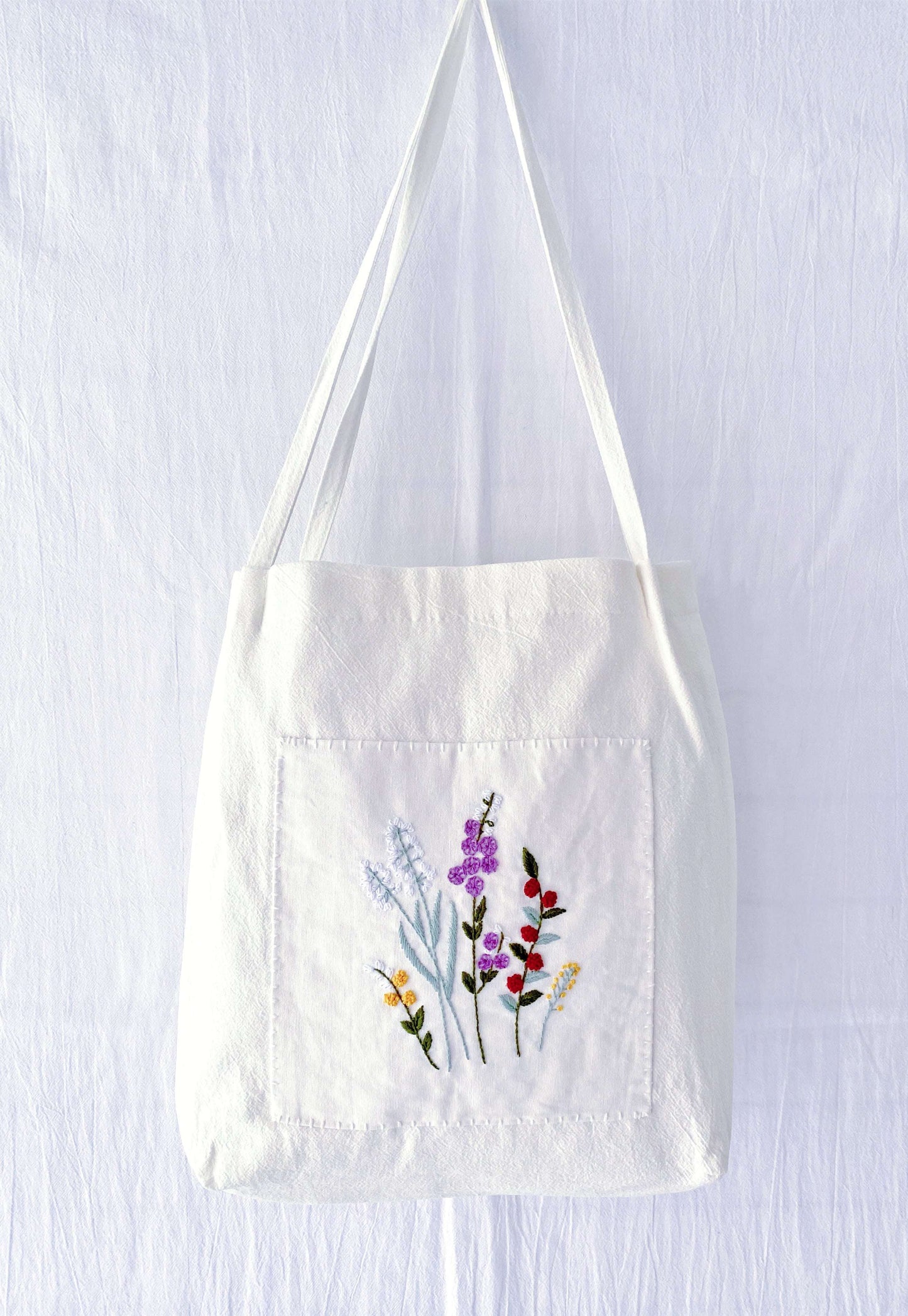 A soft linen shoulder bag where hand-embroidered flowers meet sustainable living—perfect for those who prefer the soul of handwork over the coldness of factory-made items.