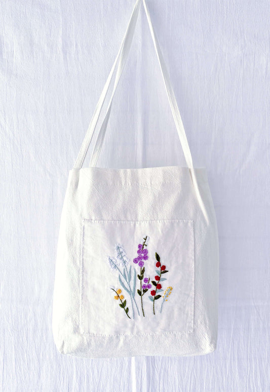 A soft linen shoulder bag where hand-embroidered flowers meet sustainable living—perfect for those who prefer the soul of handwork over the coldness of factory-made items.