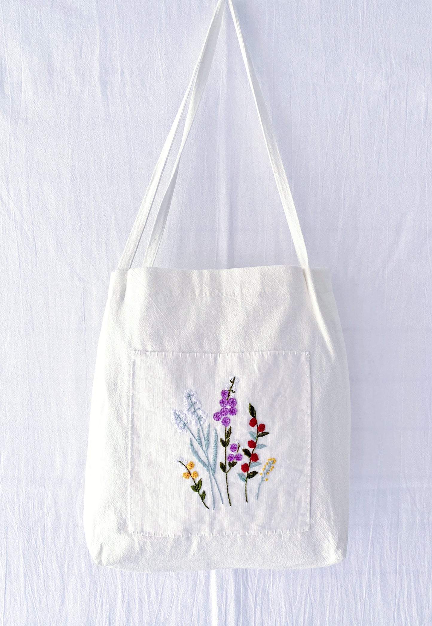 A soft linen shoulder bag where hand-embroidered flowers meet sustainable living—perfect for those who prefer the soul of handwork over the coldness of factory-made items.