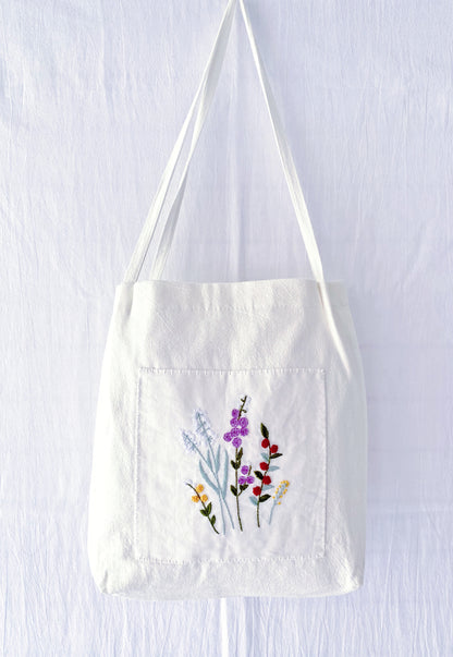 A soft linen shoulder bag where hand-embroidered flowers meet sustainable living—perfect for those who prefer the soul of handwork over the coldness of factory-made items.