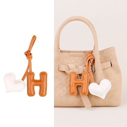 Alphabet heart charm styled with a casual tote bag